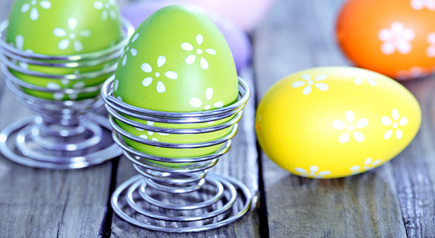Målade påskägg i äggkoppar.