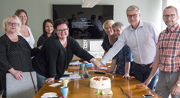 Fotografi av kommunchef och facklig representant som tillsammans ska skära i en tårta.